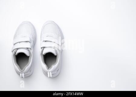 scarpe da ginnastica flat lay due bianche girl con chiusure in velcro isolate su sfondo bianco Foto Stock