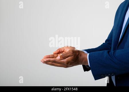 Sezione centrale di uomo d'affari con le mani cupolate su sfondo grigio Foto Stock