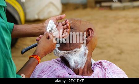 01 gennaio 2021 - Reengus, Sikar, India. Paesaggio rurale indiano, barbiere locale andare ogni giorno porta a porta per radere gli abitanti del villaggio. Foto Stock