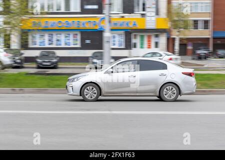 L'auto grigia sta guidando giù la strada in città. Sfocatura del movimento. In città del giorno. Vista laterale. Surgut, Russia - 17 maggio 2021. Foto Stock