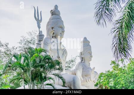 statua di lord shiv & parvati in un giardino indiano che guarda impressionante con piccoli arbusti in serata. Foto Stock