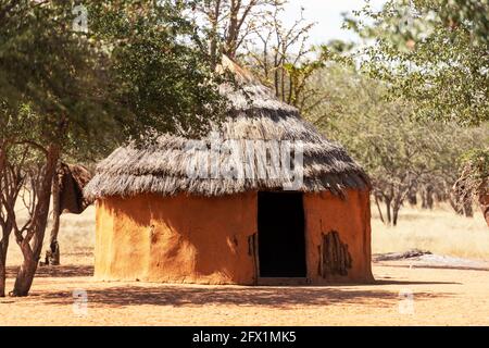 Closeup di capanna tradizionale delle tribù himba in Namibia, Africa. Tupical himbas la gente casa da argilla rossa e rami di alberi Foto Stock