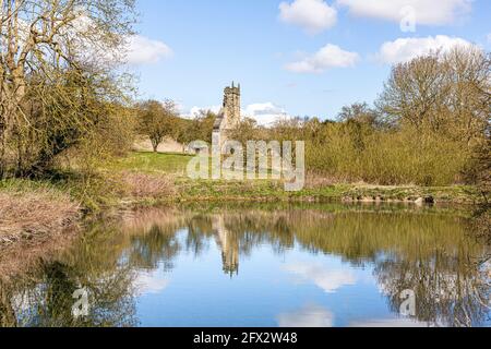 Le rovine della chiesa di St Martins si sono riflesse in un laghetto di mulino abbandonato a Wharram Percy deserted Medieval Village sul Yorkshire Wolds, North Yorkshire, Foto Stock