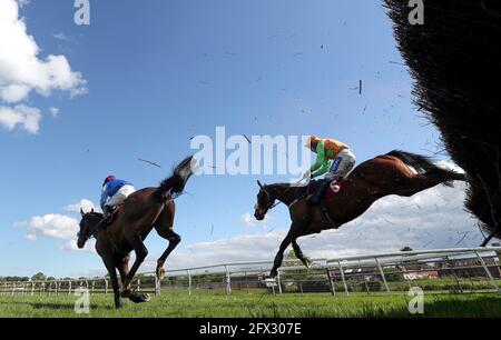 Loch Garman Aris guidato dal fantino Tom Scudamore (a destra) liberare una recinzione sulla loro strada per vincere il Tallarn Green handicap Chase a Bangor-on-Dee Racecourse. Data immagine: Martedì 25 maggio 2021. Foto Stock