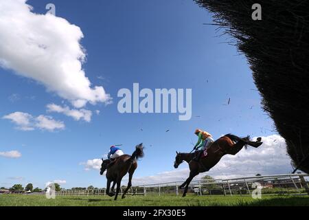 Loch Garman Aris guidato dal fantino Tom Scudamore (a destra) liberare una recinzione sulla loro strada per vincere il Tallarn Green handicap Chase a Bangor-on-Dee Racecourse. Data immagine: Martedì 25 maggio 2021. Foto Stock