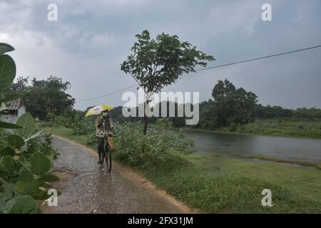 Hoogly, India. 25 Maggio 2021. Un uomo visto in bicicletta sotto la pioggia prima della caduta di 'Yaas' ciclone.Cyclone 'Yaas' probabilmente farà la caduta di terra tra Balasore e Digha Coastal zone il 26 maggio, Mercoledì mattina. Come tempesta ciclonica molto grave, può causare forti precipitazioni nei distretti costieri del Bengala Occidentale e del Nord Odisha. Credit: SOPA Images Limited/Alamy Live News Foto Stock