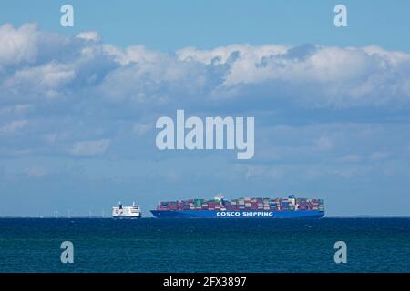 Nave con container e traghetto da Puttgarden, Isola di Fehmarn, Schleswig-Holstein, Germania Foto Stock