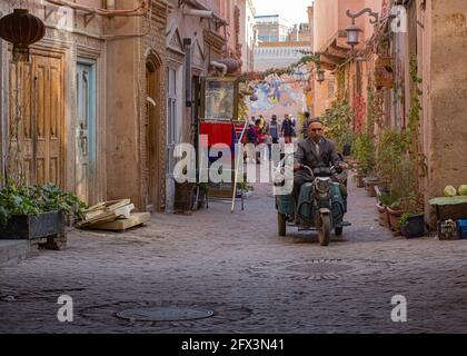 Uomo che guida una moto con rimorchio su una strada Kashgar. Cina 2019 Foto Stock