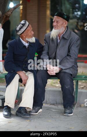 Due uomini anziani di Uighur fuori dalla Moschea Id Kah. Kashgar, Xingiang, Cina 2019 Foto Stock