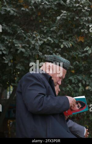 Uighur vecchio che legge fuori della Moschea Id Kah .Kashgar, Xingiang, Cina 2019 Foto Stock