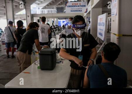 Un'infermiera volontaria inietta una dose del vaccino Sinovac COVID-19 ad un operatore sanitario durante un programma di vaccinazione all'interno di uno stadio sportivo a Marikina City, ad est di Manila, Filippine. Foto Stock