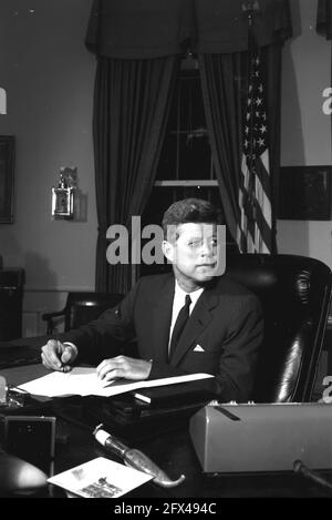 23 ottobre 1962 il presidente John F. Kennedy sedeva alla sua scrivania con la penna in mano durante la proclamazione della firma dell'interdizione della consegna di armi di difesa a Cuba. White House, Washington, D.C. Please credit:'Cecil Stoughton, White House/John F. Kennedy Presidential Library and Museum, Boston' Foto Stock