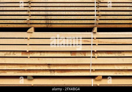 Legno accatastato in una segheria. Collo di bottiglia sul mercato del legname segato Foto Stock