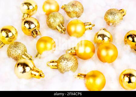 Decorazioni natalizie in oro brillante (nastri, baubles, archi, ornamenti) piatte su bianco fondo di neve artificiale. Natale e Capodanno tradizionale Foto Stock