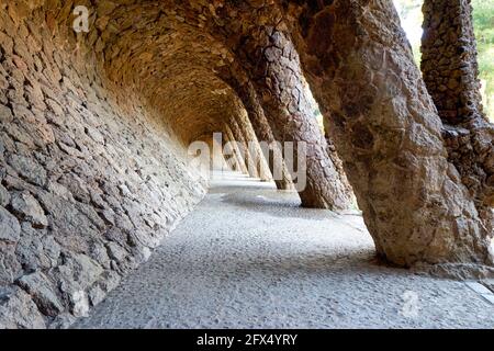 Barcellona. Catalogna. Spagna. Un sentiero colonnato nel Parco Guell, progettato da Antoni Gaudi Foto Stock