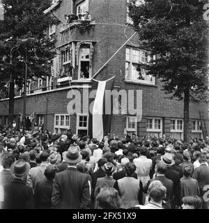 [Incontro festivo all'angolo di Euterpedstraat e Rubensstraat, in occasione del cambio di nome della strada precedente in Gerrit van der Veenstraat. Sulla facciata dell'edificio ad angolo una bandiera olandese copre il nuovo cartello stradale. Vedova di Gerrit van der Veen ha tenuto un discorso], 28 giugno 1945, celebrazioni per la liberazione, seconda guerra mondiale, Paesi Bassi, foto agenzia stampa del xx secolo, notizie da ricordare, documentario, fotografia storica 1945-1990, storie visive, Storia umana del XX secolo, che cattura momenti nel tempo Foto Stock