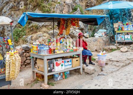 Anziana donna stallholder e snack stalle a Chinchero, un piccolo villaggio rurale andino nella Valle Sacra, provincia di Urubamba, regione di Cusco, Perù Foto Stock