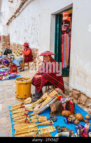 Negoziante che vende strumenti musicali come souvenir a Chinchero, un villaggio andino rustico nella Valle Sacra, provincia di Urubamba, regione di Cusco, Perù Foto Stock