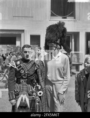 Prove generali per il Tattoo della NATO ad Arnhem. Ragazza con cappello da orso accanto a Scotsman, 11 luglio 1960, capo, bambini, Militare, prove, tatuaggi, Paesi Bassi, foto agenzia stampa del XX secolo, notizie da ricordare, documentario, fotografia storica 1945-1990, storie visive, Storia umana del XX secolo, che cattura momenti nel tempo Foto Stock