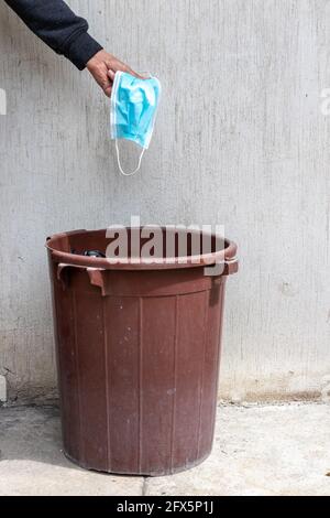 maschera di faccia all'interno del garbage can , covid-19 pandemia è sopra concetto Foto Stock