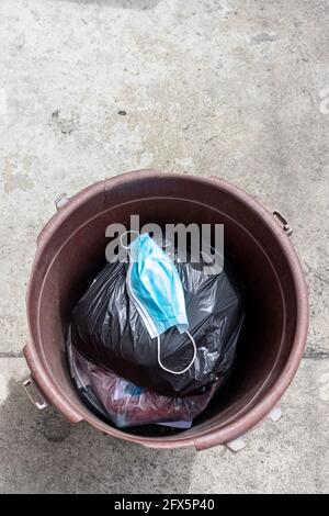 maschera di faccia all'interno del garbage can , covid-19 pandemia è sopra concetto Foto Stock