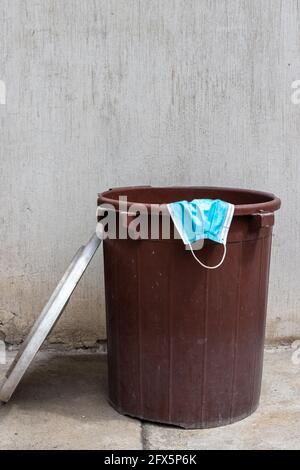 maschera di faccia all'interno del garbage can , covid-19 pandemia è sopra concetto Foto Stock