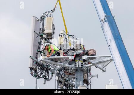 Detroit, Michigan - i lavoratori aggiornano una torre cellulare AT&T alla tecnologia 5G più veloce. Foto Stock