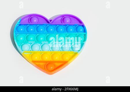 Giocattolo antistress pop it. Il fidget sensoriale arcobaleno isolato su sfondo bianco. Nuovo giocattolo alla moda in silicone. Foto Stock