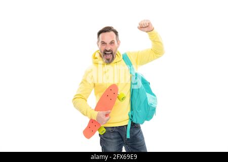 l'uomo felice maturo porta lo zaino e il bordo del penny. ragazzo anziano sorridente di nuovo a scuola Foto Stock