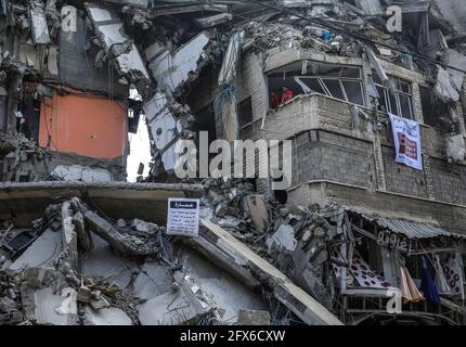 Gaza, Palestina. 22 maggio 2021. I palestinesi si sono visti tra case distrutte dopo il cessate il fuoco tra Israele e i militanti di Gaza nella città di Gaza. Il diplomatico STATUNITENSE Antony Blinken ha promesso sostegno per contribuire a ricostruire la striscia di Gaza martoriata e a costellare una tregua tra Hamas e Israele, ma ha insistito che i governanti militanti islamici del territorio non avrebbero beneficiato di alcun aiuto. Credit: SOPA Images Limited/Alamy Live News Foto Stock