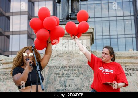 HANA Abdur-Rahim, un attivista locale e organizzatore per i gruppi della materia Black Lives a Columbus, tiene palloncini rappresentanti di diverse vittime della brutalità della polizia prima di rilasciarli in aria. I sostenitori della Black Lives Matter hanno organizzato una veglia per le vittime della brutalità della polizia di fronte allo Stato dell'Ohio in commemorazione dell'anniversario della morte di George Floyd per mano della polizia di Minneapolis un anno fa. Cynthia Brown, un fondatore del movimento heartbeat dell'Ohio, MC'ed the Vigil, e la maggior parte dei relatori alla veglia erano familiari o amati di individui che erano morti a causa della polizia brutale Foto Stock