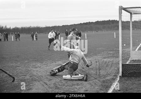 Hockey Laren contro Amsterdam, portiere Wolf (Laren) controlla la palla, quando Voigt (Amsterdam) ha colpito, 20 dicembre 1964, hockey da campo, portiere, I Paesi Bassi, foto agenzia stampa del XX secolo, notizie da ricordare, documentario, fotografia storica 1945-1990, storie visive, Storia umana del XX secolo, che cattura momenti nel tempo Foto Stock