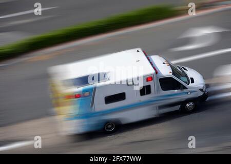 Un'ambulanza corre per rispondere alla scena di un'emergenza. Foto Stock