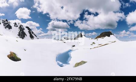 Il piccolo lago alpino esce dal disgelo in primavera Foto Stock