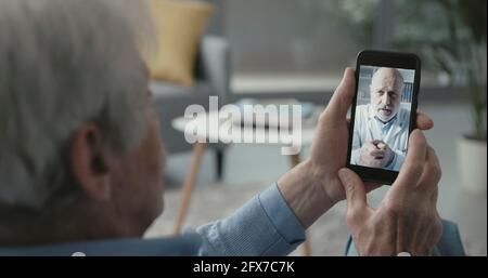 Video dell'uomo anziano che chiama il suo medico in linea da casa, concetto di telemedicina Foto Stock