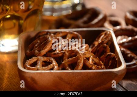 Pretzel duri o uno spuntino di pretzel salati per una festa in stile rustico tavolo in legno con bicchiere di birra Foto Stock