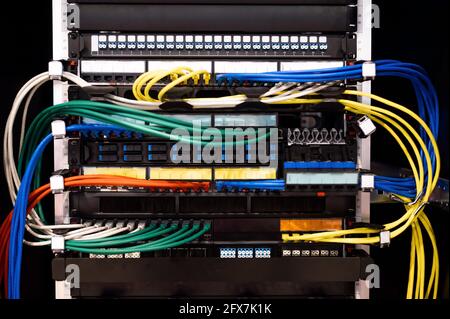 Al sistema sono collegate file multicolore di cavi di rete Foto Stock