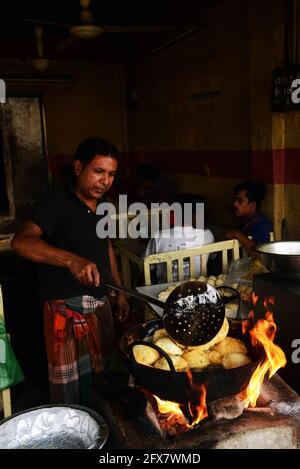 Un uomo del Bangladesh frittura di pane puri a Dhaka, Bangladesh. Foto Stock