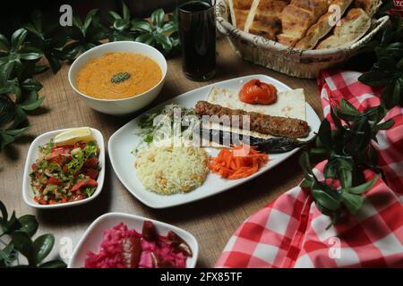 Kebab turco Adana con verdure fresche su pane piatto Vista dall'alto, piatto Foto Stock