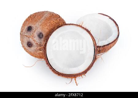 Noci di cocco intere e incrinate isolate su sfondo bianco. Frutta di cocco sbucciata che mostra i tre pori caratteristici. Tagliare a metà la chiocciola di cocco. Foto Stock