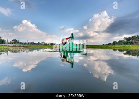 Bao Loc City, Provincia di Dong Nai, Viet Nam - 16 aprile 2021: Un pescatore sta lavorando su una laguna di acquacoltura a Bao Loc City, Provincia di Dong Nai, Vietna Foto Stock