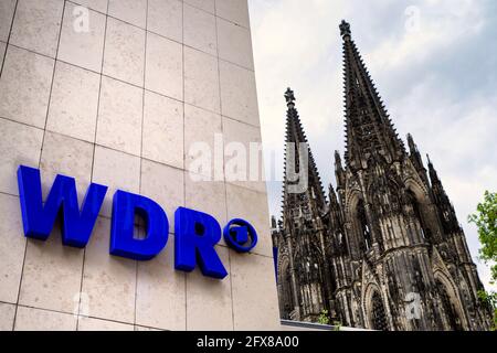 Colonia, Germania - 23 maggio 2021: Logo sulla facciata del WDR Broadcasting Building, sullo sfondo il logo della Cattedrale di Colonia sulla facciata del Th Foto Stock