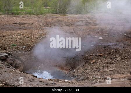 Il geyser in Islanda continua a gorgogliare dopo un'eruzione in un paesaggio vulcanico in Islanda. Mettere a fuoco sulle bolle bollenti Foto Stock