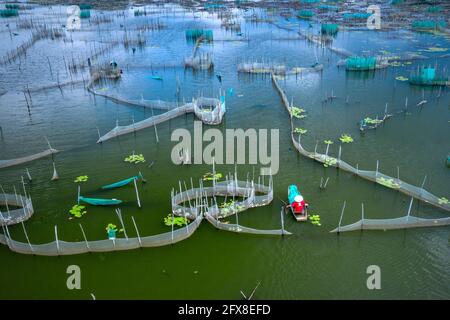 Bao Loc City, Provincia di Dong Nai, Viet Nam - 16 aprile 2021: Un pescatore sta lavorando su una laguna di acquacoltura a Bao Loc City, Provincia di Dong Nai, Vietna Foto Stock