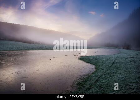 Grande corpo di acqua di alluvione congelata adiacente al fiume Wye a Llandogo. Foto Stock