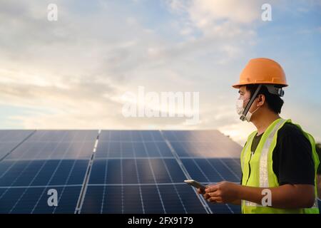 Tecnico di celle solari, l'azienda agricola solare o pannello solare con ingegnere che lavora per il controllo e la manutenzione delle attrezzature a industria energia solare, Fotovoltaico Foto Stock