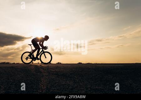 Vista laterale dello sportivo in bicicletta da corsa con casco protettivo Foto Stock