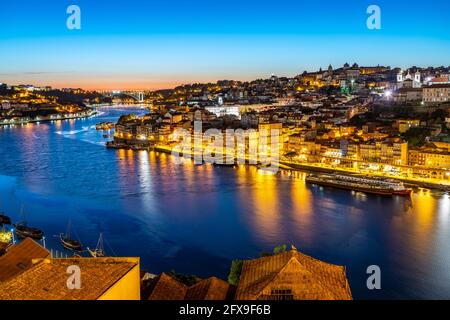 Blick über den Fluss Douro auf die Altstadt von Porto in der Abenddämmerung, Portogallo, Europa | Vista sul fiume Douro fino al centro storico di P Foto Stock