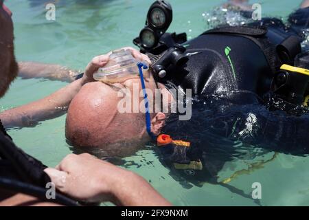 Panglao, Filippine - 29 aprile 2021: Subacqueo, istruttore in acque confinate insegnamento, studio, valutazione delle competenze, abilità di salvataggio Foto Stock