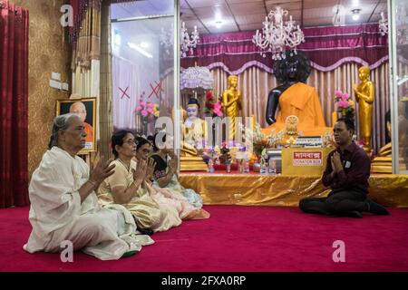 Dhaka, Bangladesh. 26 Maggio 2021. La famiglia buddista offre preghiere di fronte ad una statua di Buddha durante le celebrazioni. Buddha Purnima, il più grande festival religioso della Comunità buddista, segna l'avvento, il raggiungimento del nirvana (o illuminazione) e la partenza del Signore Gautama Buddha. Credit: SOPA Images Limited/Alamy Live News Foto Stock